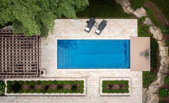 A backyard with a pool deck made with light coloured brick