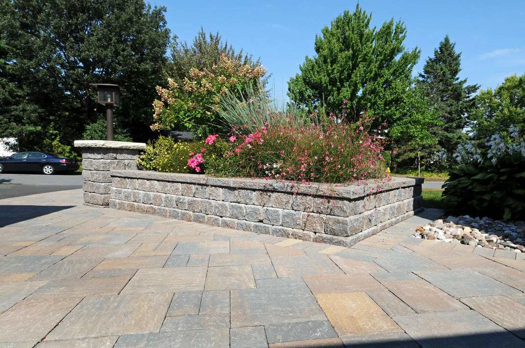 a stone driveways with a centre island with plants