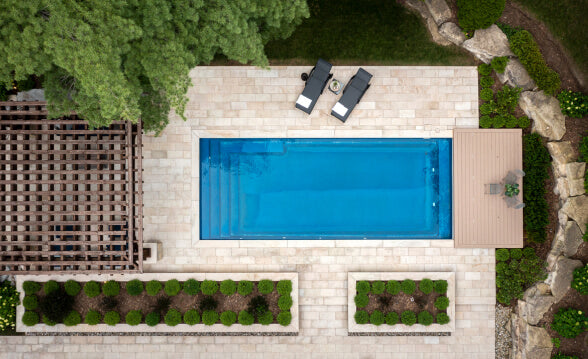 A backyard with a pool deck made with light coloured brick